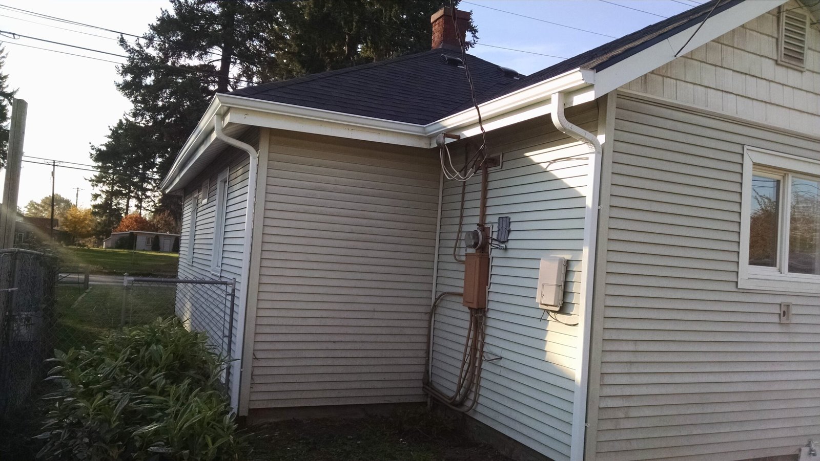 White gutters and downspouts around an inside roof corner