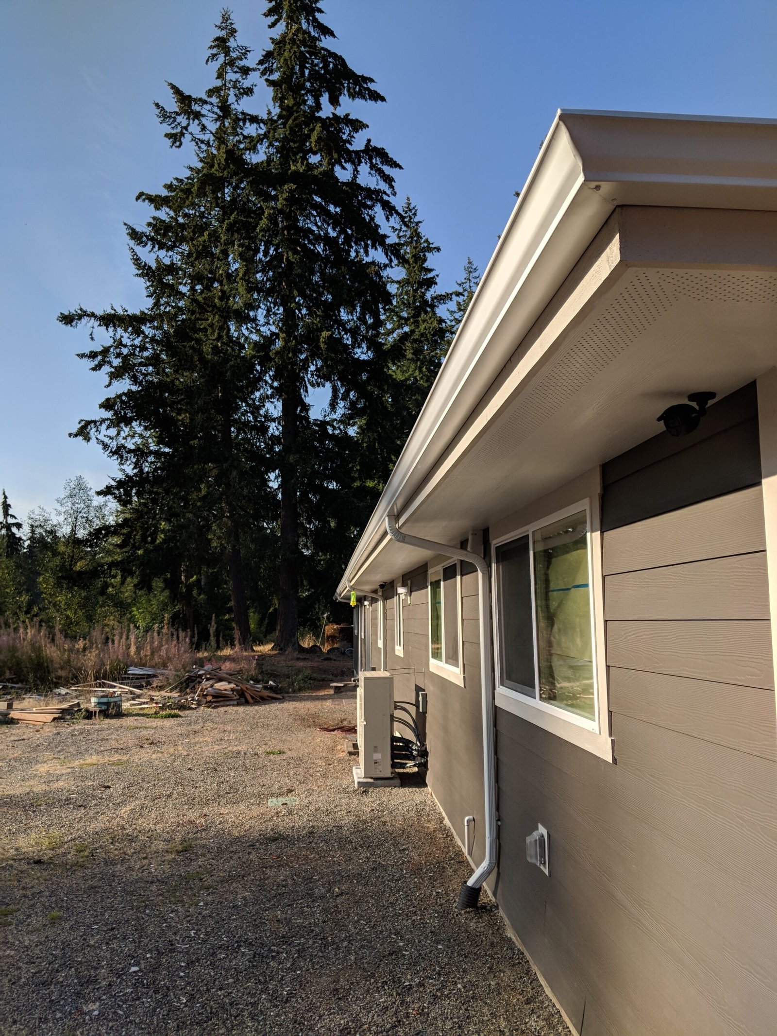 White gutter and downspout along the eaves of a home
